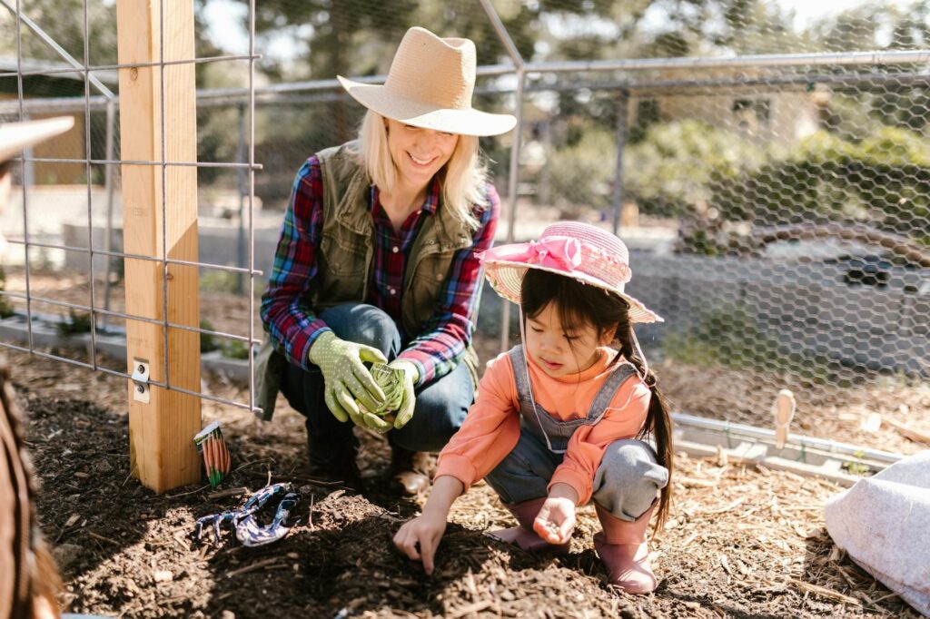 woman and a child planting seeds on the ground